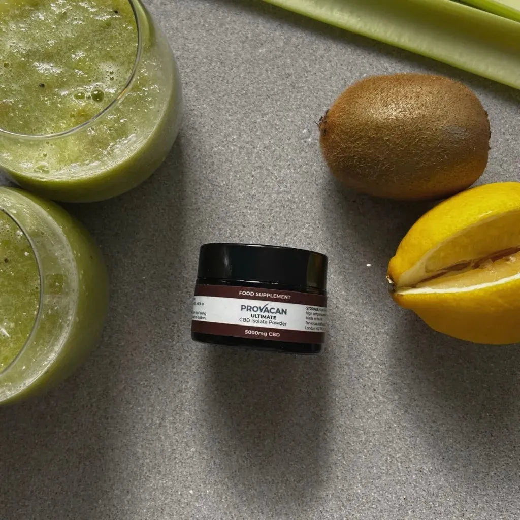 Jar of Provacan Ultimate CBD Isolate Powder 5000mg CBD on a kitchen surface surrounded by smoothies and fruits.
